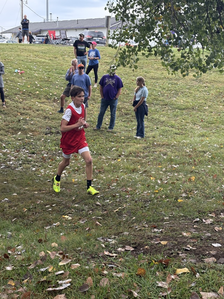 Car runs in a red uniform with bright green shoes.