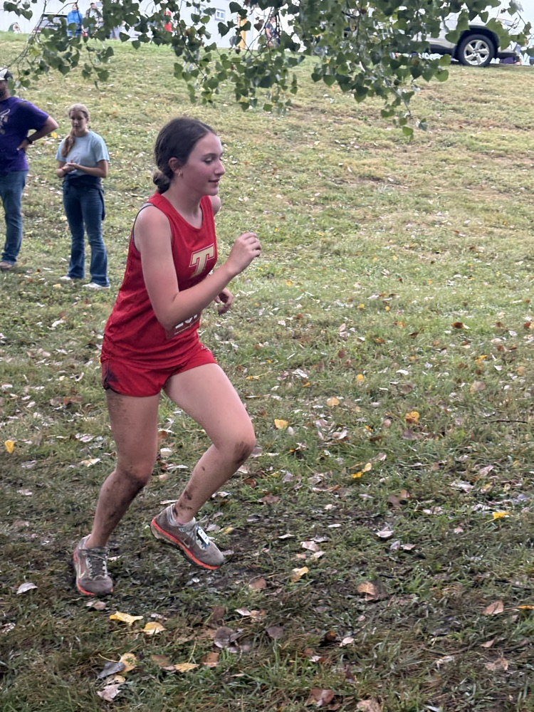 Nomy🩷 in a red uniform covered in mud from a spill she has taken on the course runs hard.