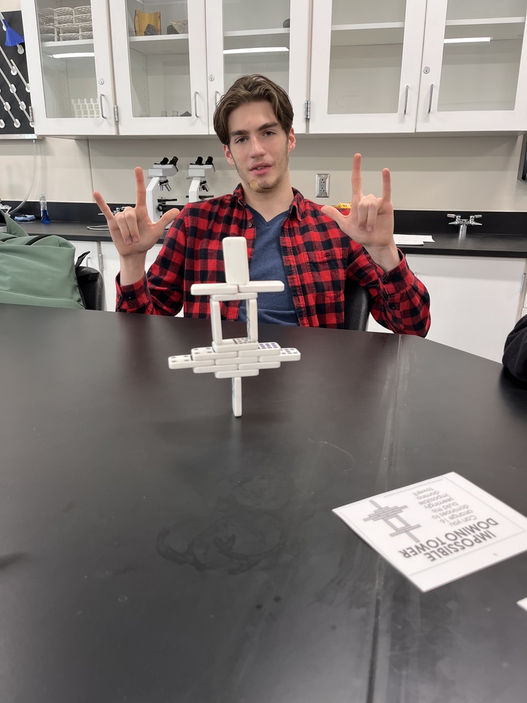 A student with his completed domino tower.