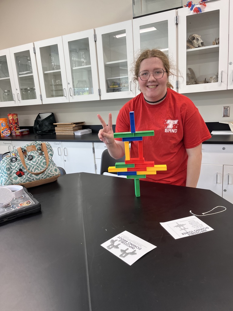 A student with her completed domino tower.