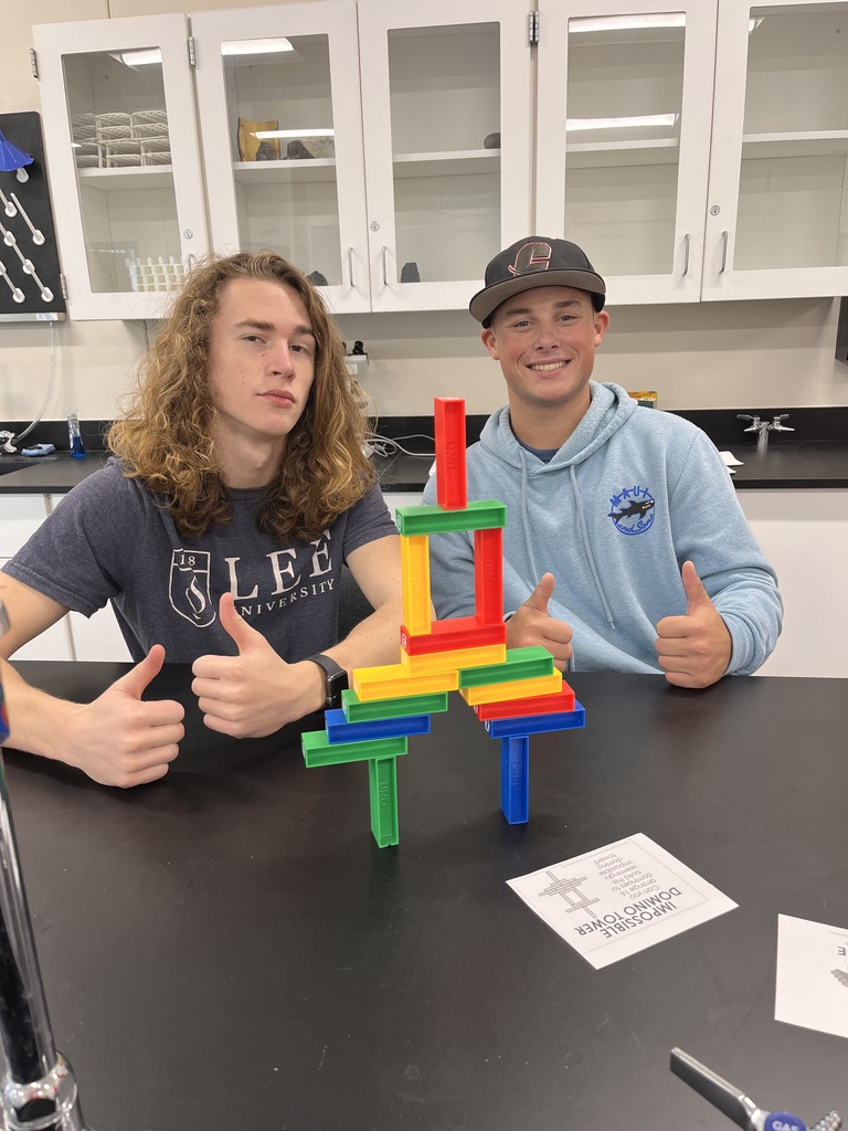 Two students with their completed domino bridge.