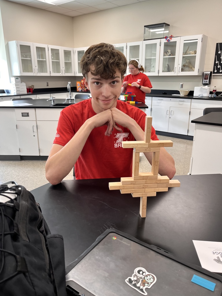 A student with his completed domino tower.