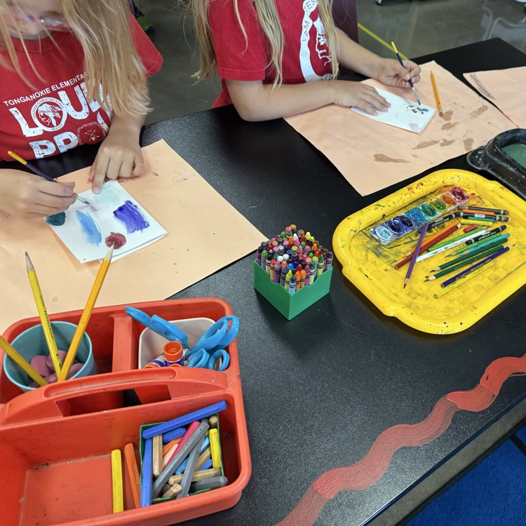 two students painting with watercolors