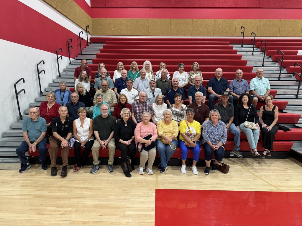 graduates sitting on the red stairs on chieftain arena gym
