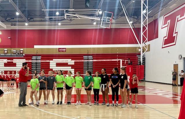 volleyball players line up in a gymnasium