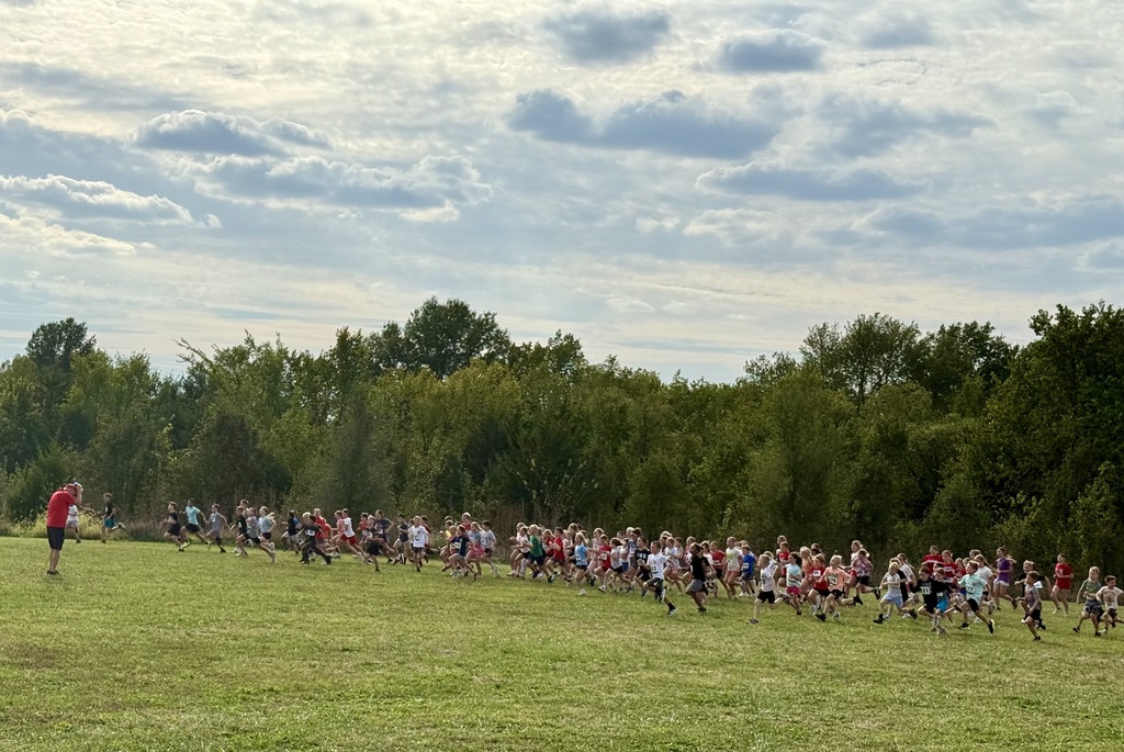 elementary school kids take off running from the start line as Coach Tollefson yells GO