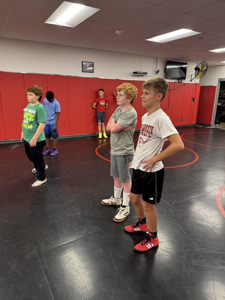 Middle school boys listening to a wrestling coach talk