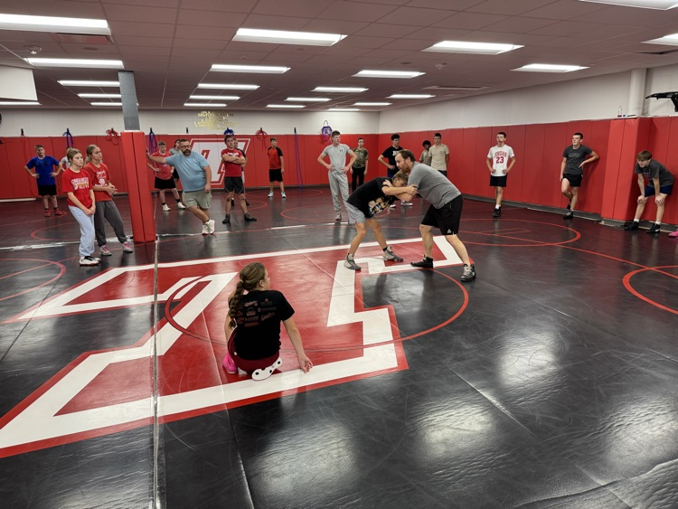 Middle school wrestlers, watching a coach demonstrate a position