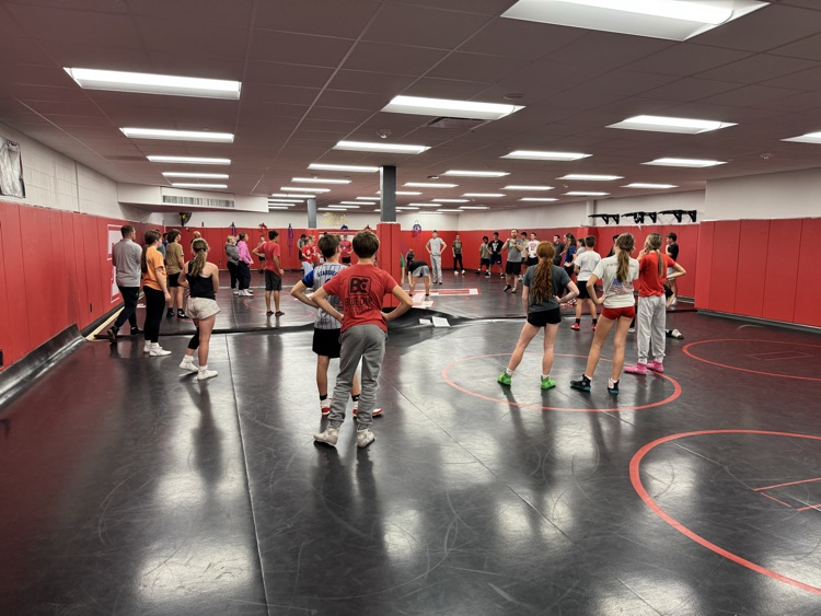 middle school coach demonstrating position for wrestlers