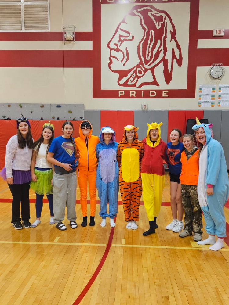 eighth grade girls wearing various costumes, standing in a gymnasium