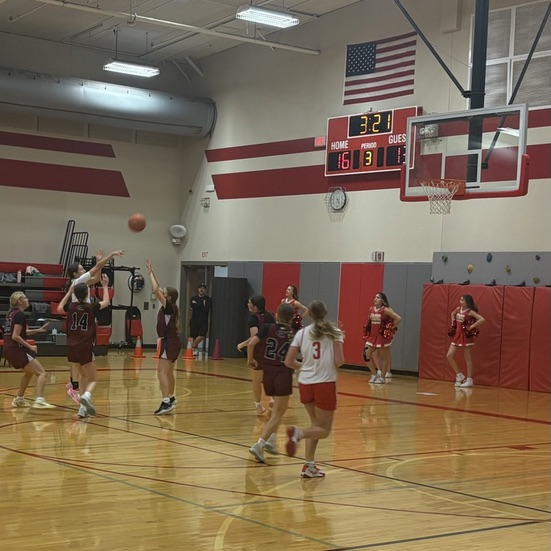 girls shooting basketball against maroon jersey wearing girls .