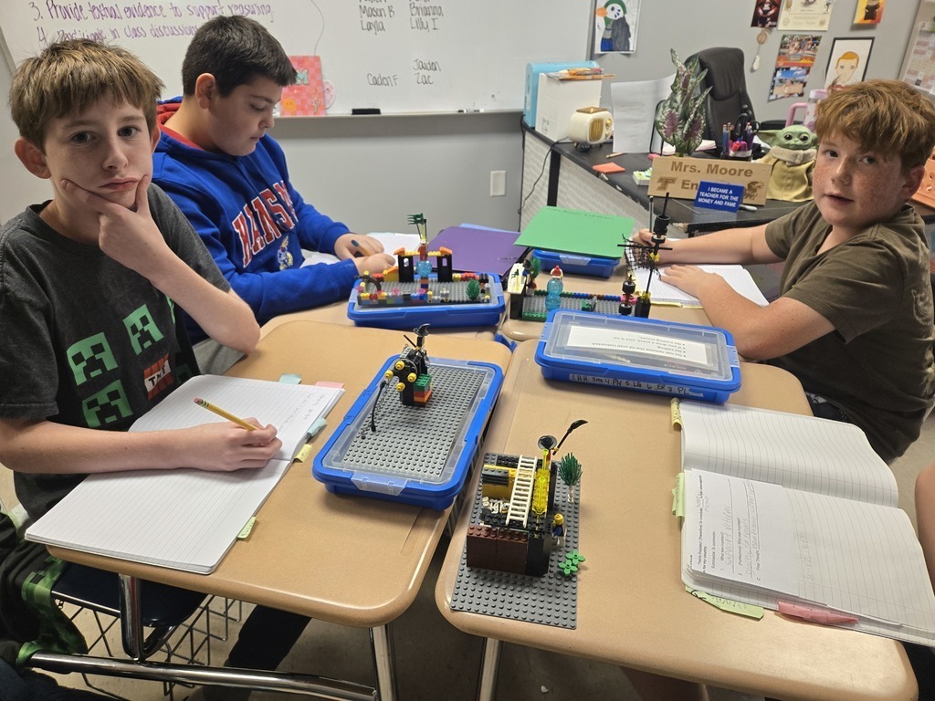 two boys writing at brown school desks
