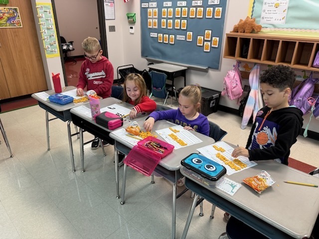 Students working on filling ten frames with 67 gold fish. 