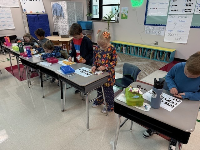 Students working on filling ten frames with 67 gold fish. 