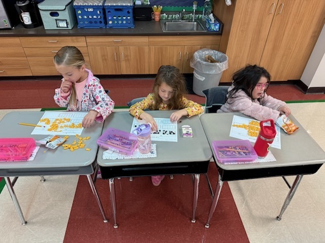 Students working on filling ten frames with 67 gold fish. 