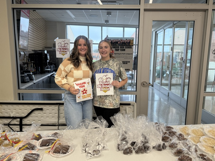 two girls holding white pieces of paper with the Ronald McDonald House logo that say thank you