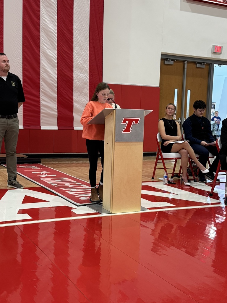Georgia stands at a podium in Chieftain Arena during the Veterans Day Ceremony