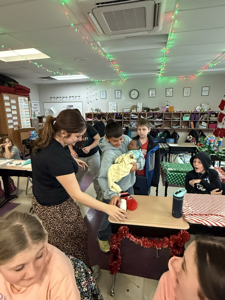 fifth graders hold a lifelife baby doll