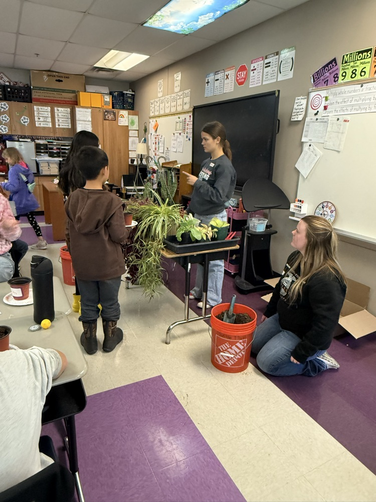 two high school students speak to fifth graders about plants