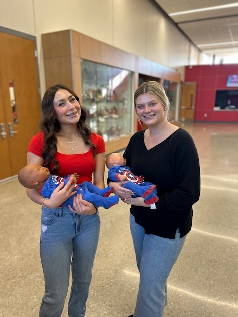 Student volunteers hold baby simulators that they passed out to Reality U participants.