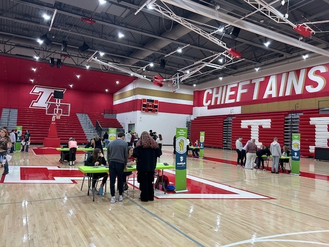 Students navigate to different tables where they have to pay bills as part of the financial simulation