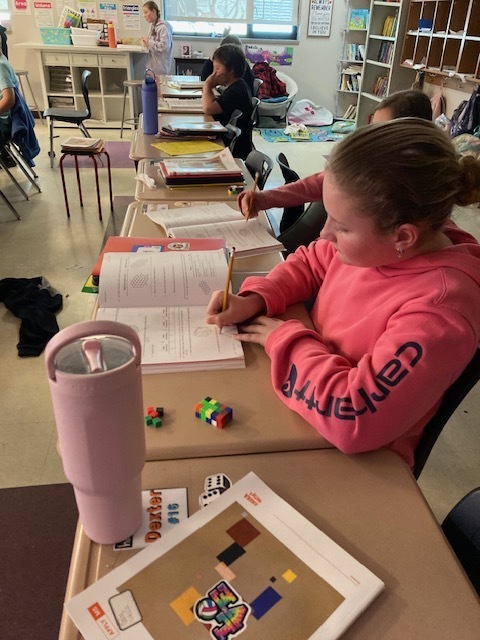 Students in Mrs. Maize's math class use math manipulatives to create a conceptual understanding of finding the volume of a rectangular prism.