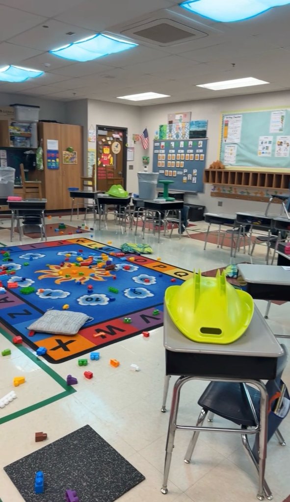 The kindergarten classroom with desks moved, materials all over, and cabinet doors open.