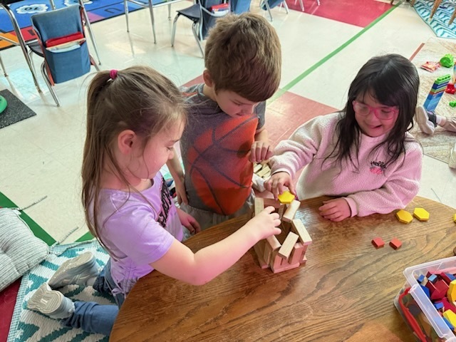 Students using shapes and Jenga blocks to create a leprechaun trap.