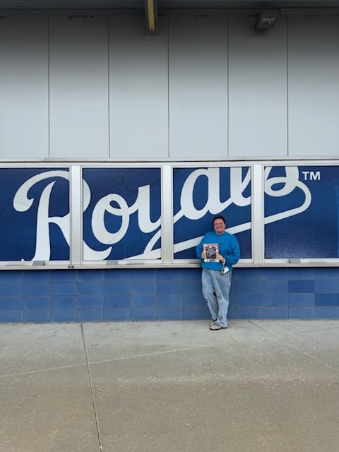 Mrs. D at the Royals stadium with her book.