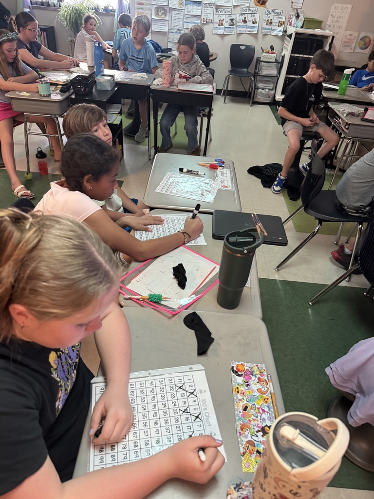 4th grade students in Mrs. Wolff's classroom prepare for upcoming state assessments by practicing their skills using a number grid.