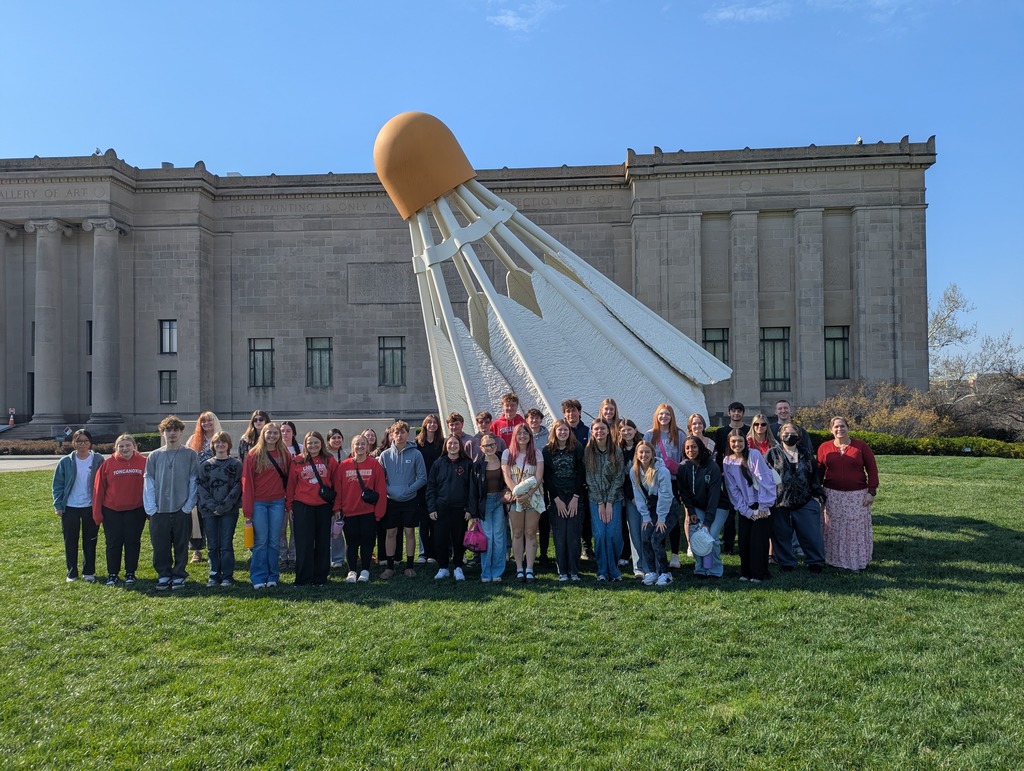 Large group standing in front of the worlds largest shuttlecock