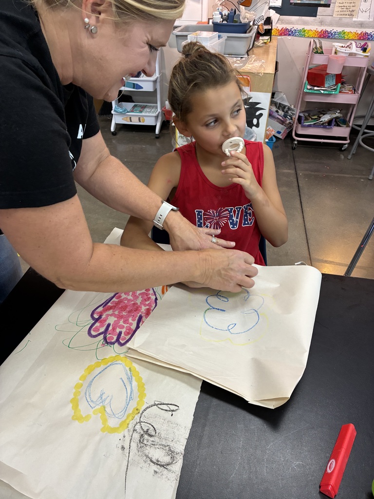 student in red tank top making a pink hand with a purple outline 