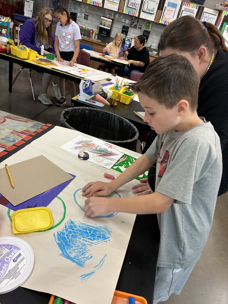 student making a blue circle with texture rubbings 