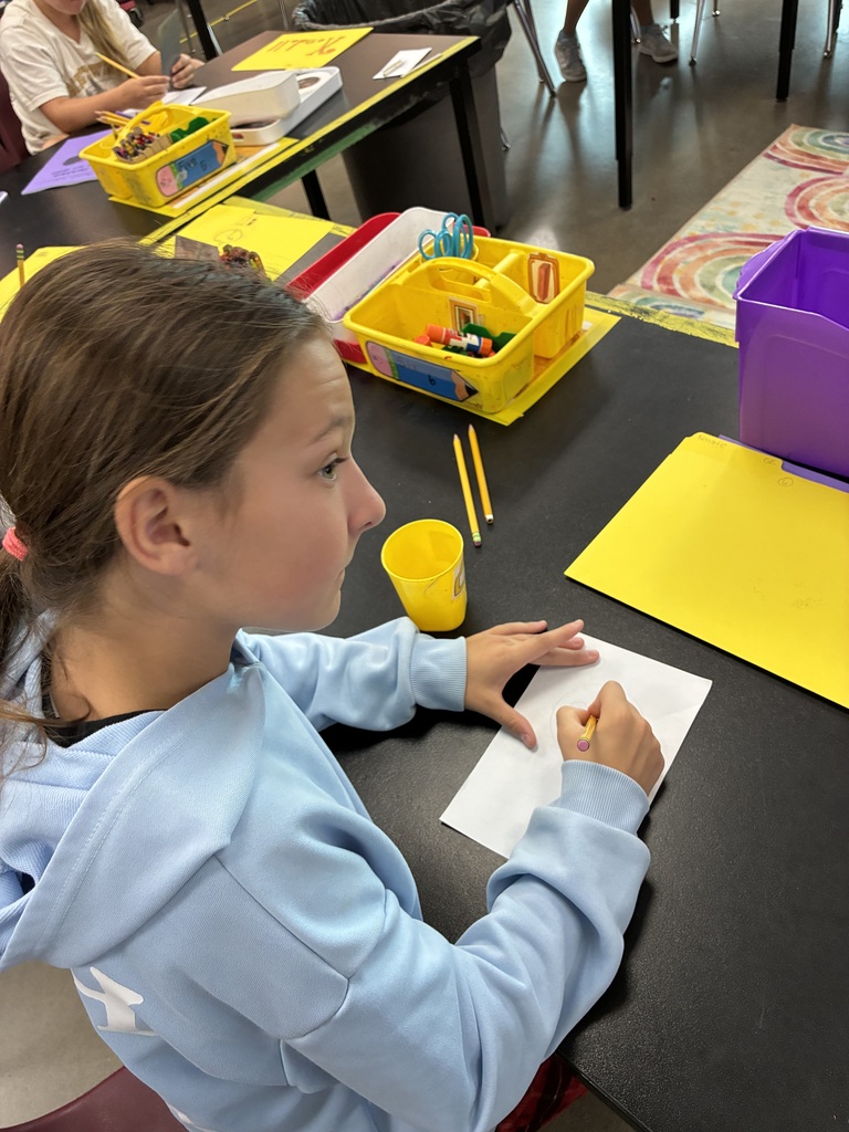 student in blue sweatshirt drawing a portrait 