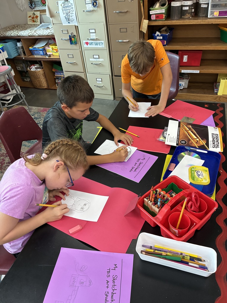 three students are working hard on their self portraits 