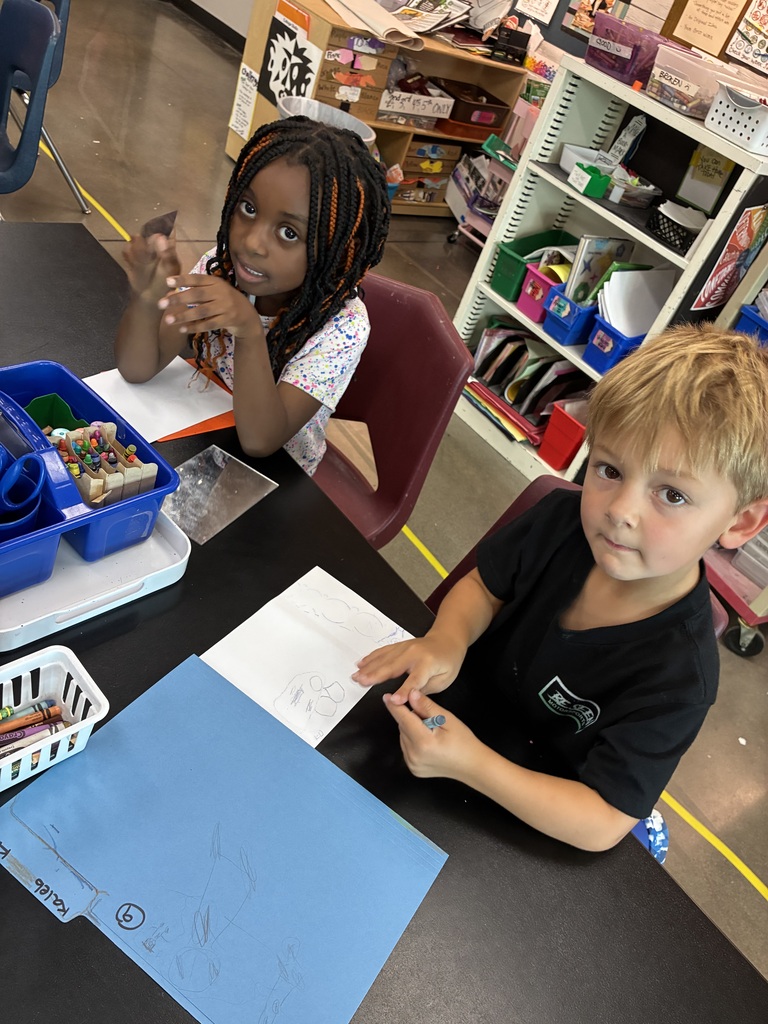 boy in black shirt and girl in white shirt drawing self portraits