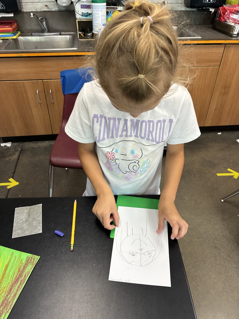 girl in white t-shirt drawing a self portrait