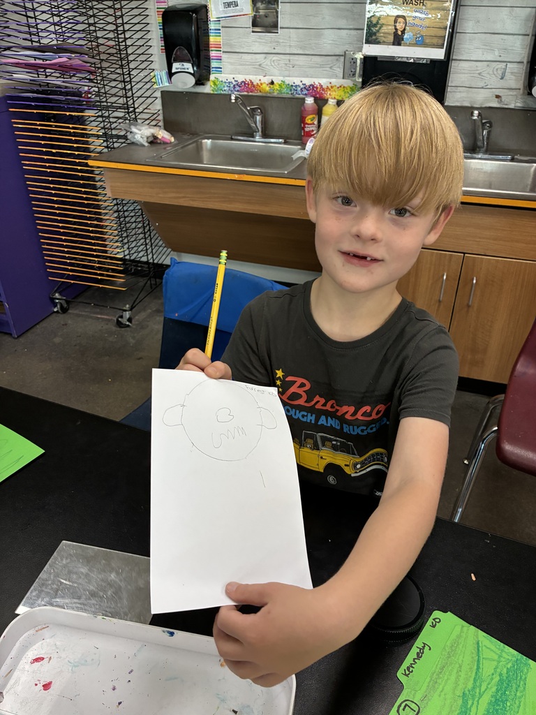 boy holding up his self portrait