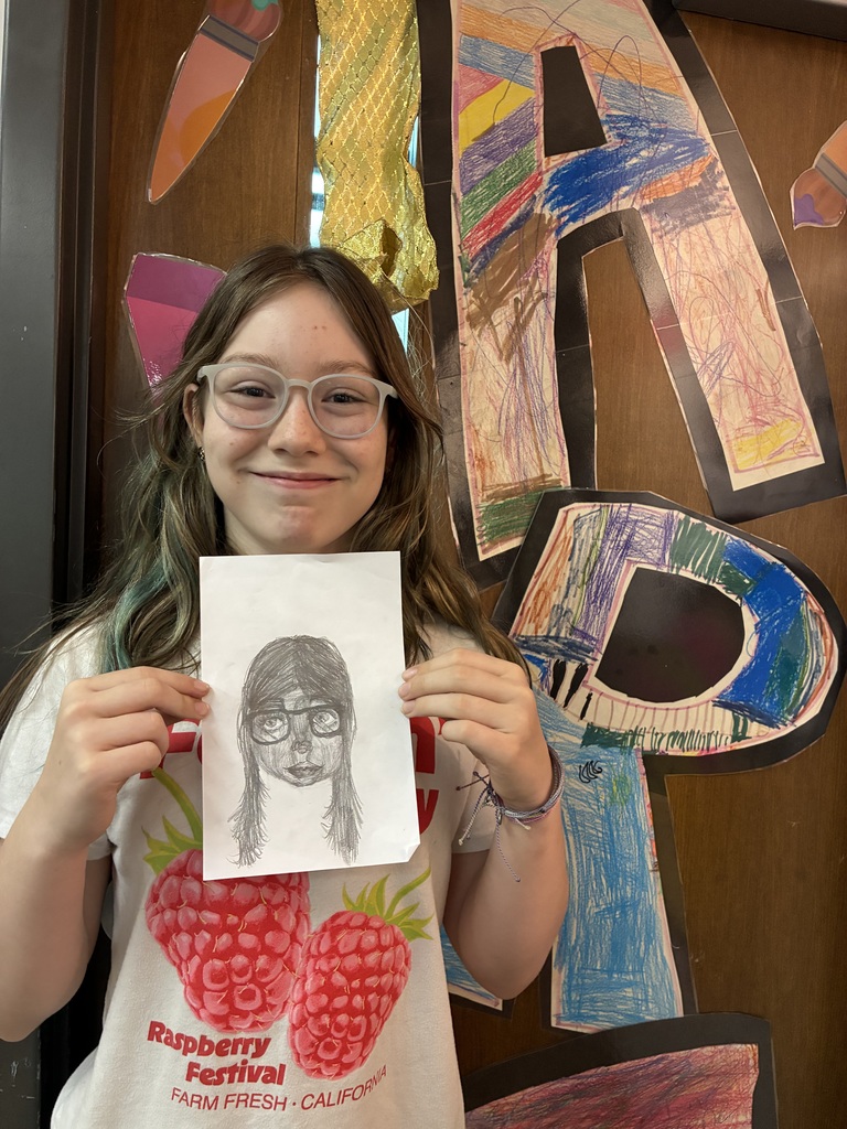 Student holding drawing of herself