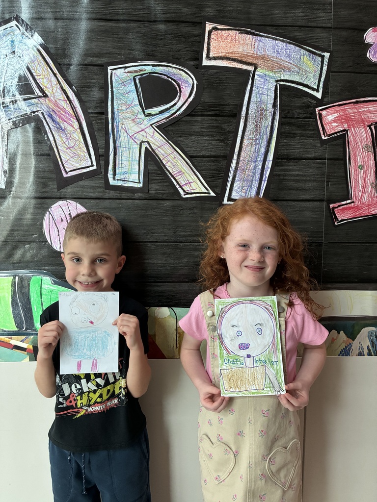 Boy and girl holding drawings of themselves