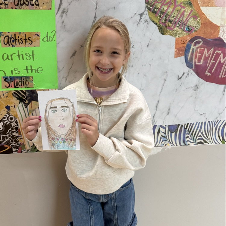 Emerie F. 4th grade holding her self portrait