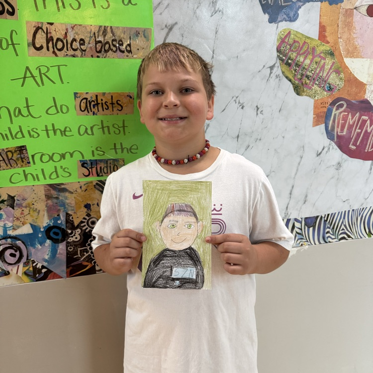Beau M. 4th grade holding her self portrait