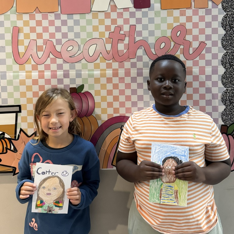 Carter D. and Jaden D. 3rd grade holding her self portrait