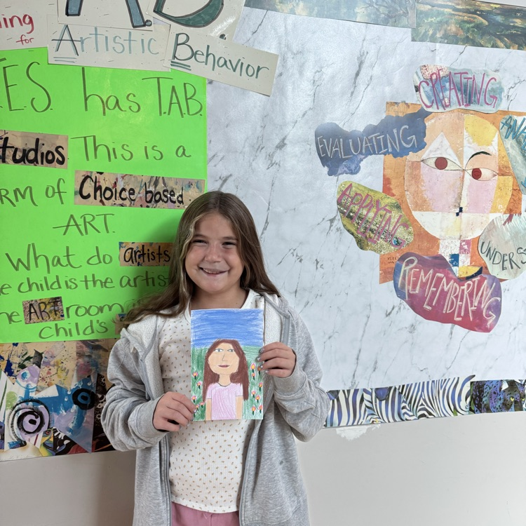 Millie M. 5th grade holding her self portrait