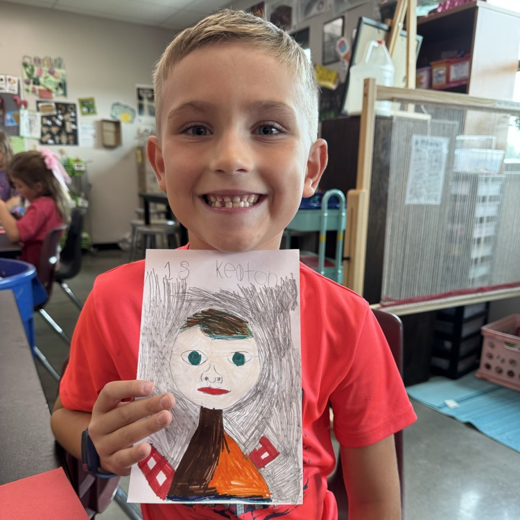 Keaton M. 1st grade holding her self portrait
