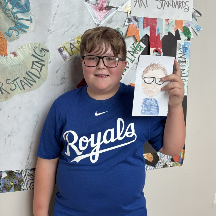 Jace G. 5th grade holding her self portrait