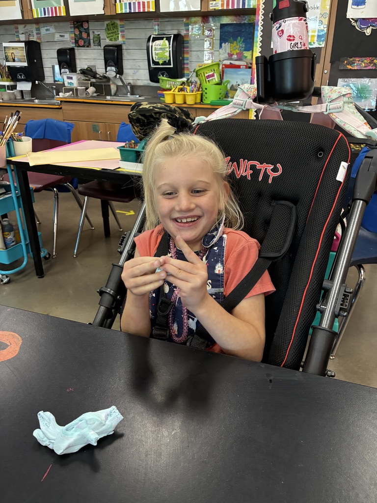 girl in coral shirt playing with white clay