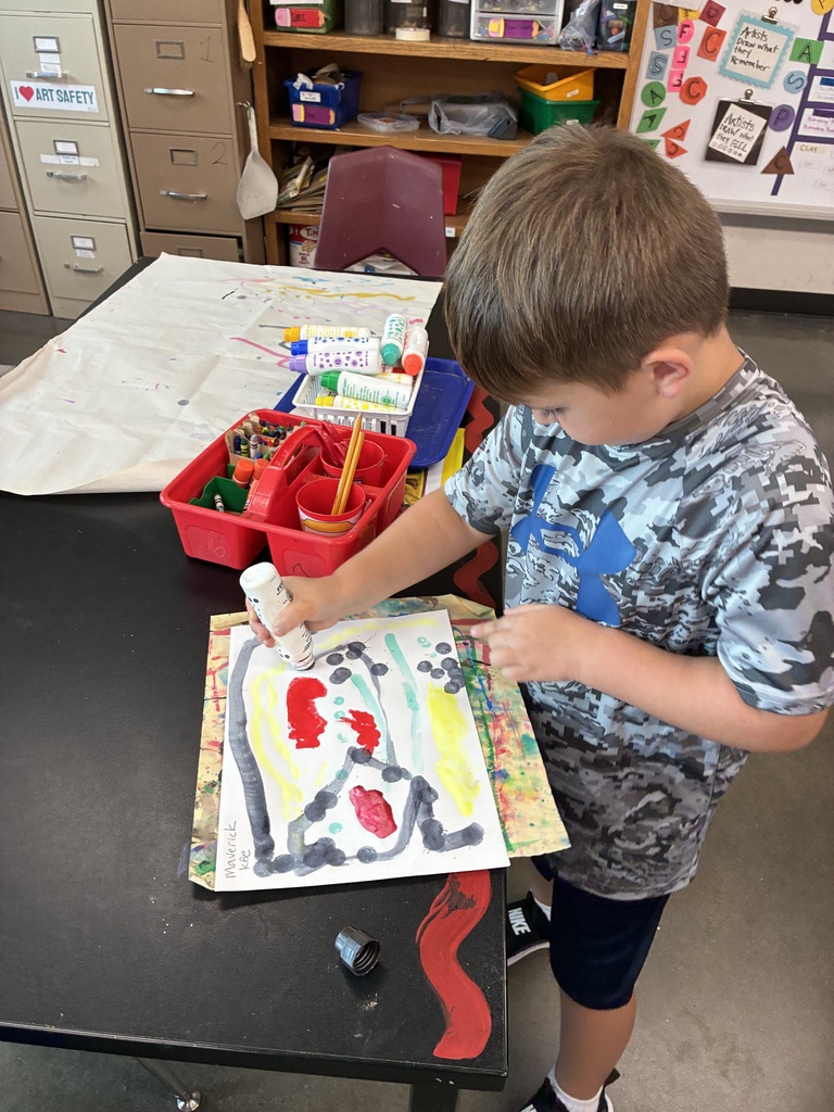 Kindergarten student with dauber painting lines and colors and dots