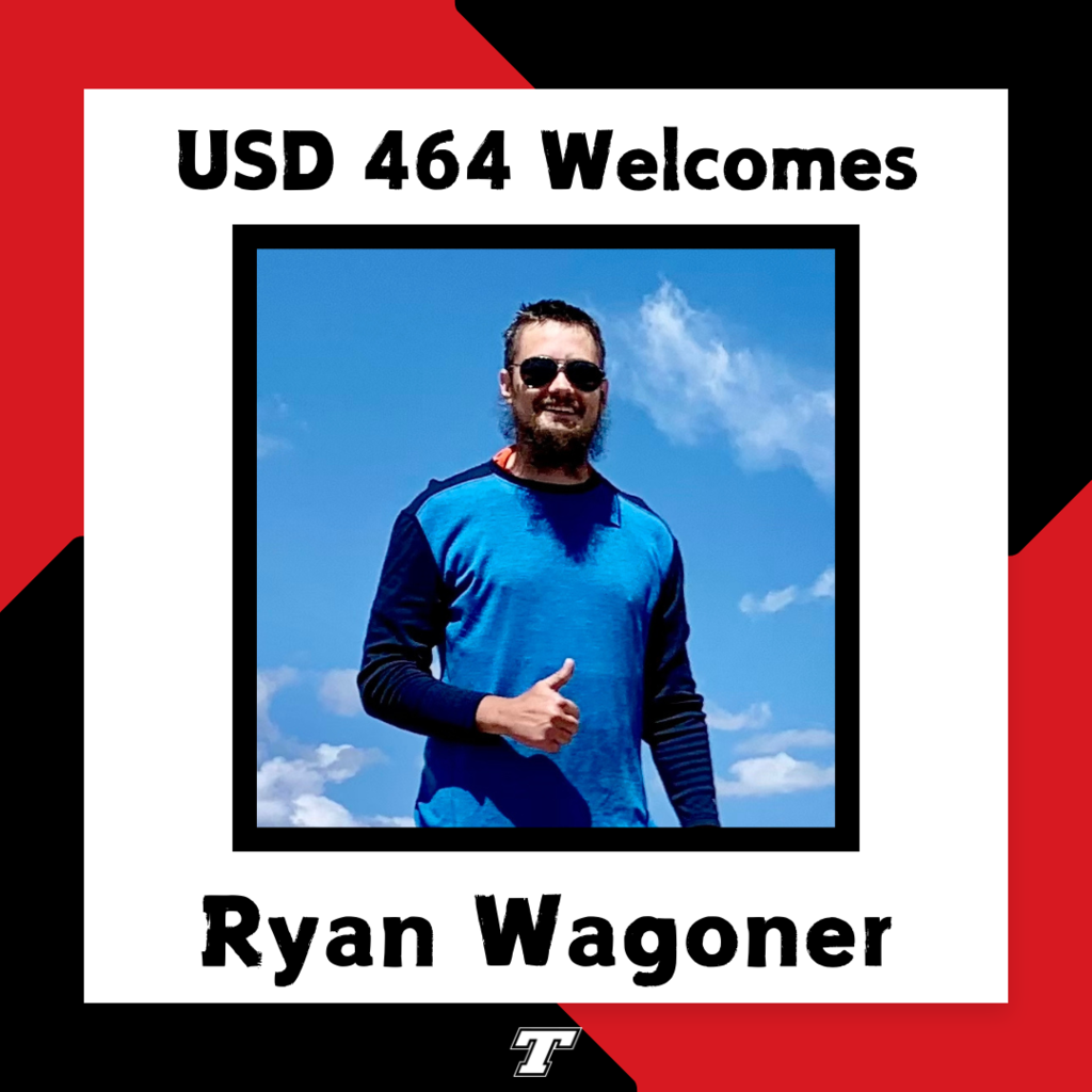 Ryan Wagoner wearing a long sleeved blue tech shirt, giving a thumbs up; blue sky and white clouds in the background