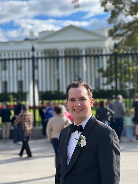 wesley williams in a tuxedo, standing in front of the white house